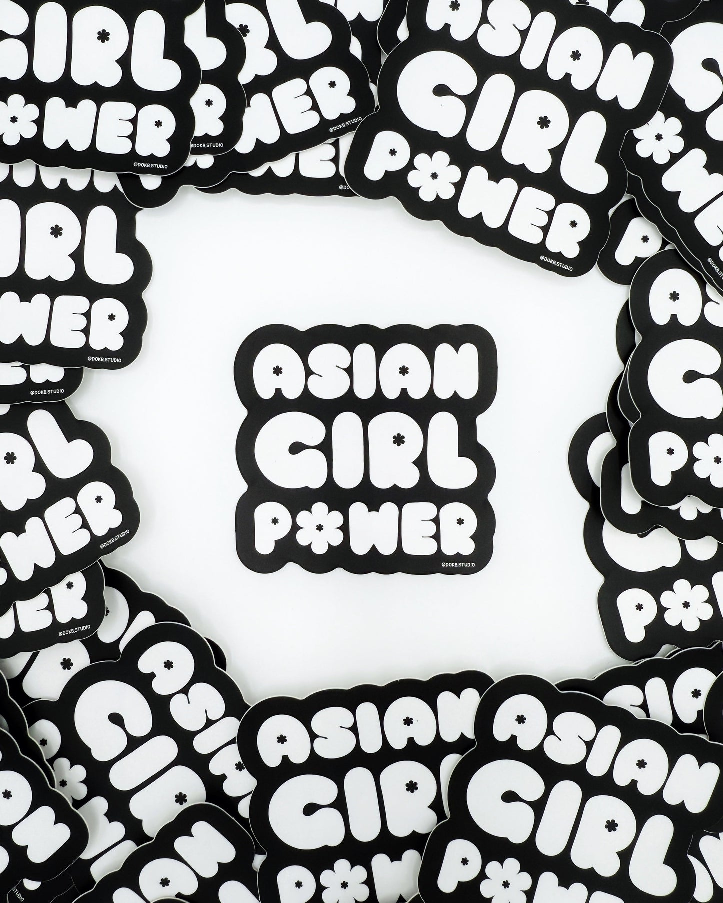 A collection of black and white stickers with the phrase 'ASIAN GIRL POWER' arranged in a pattern.